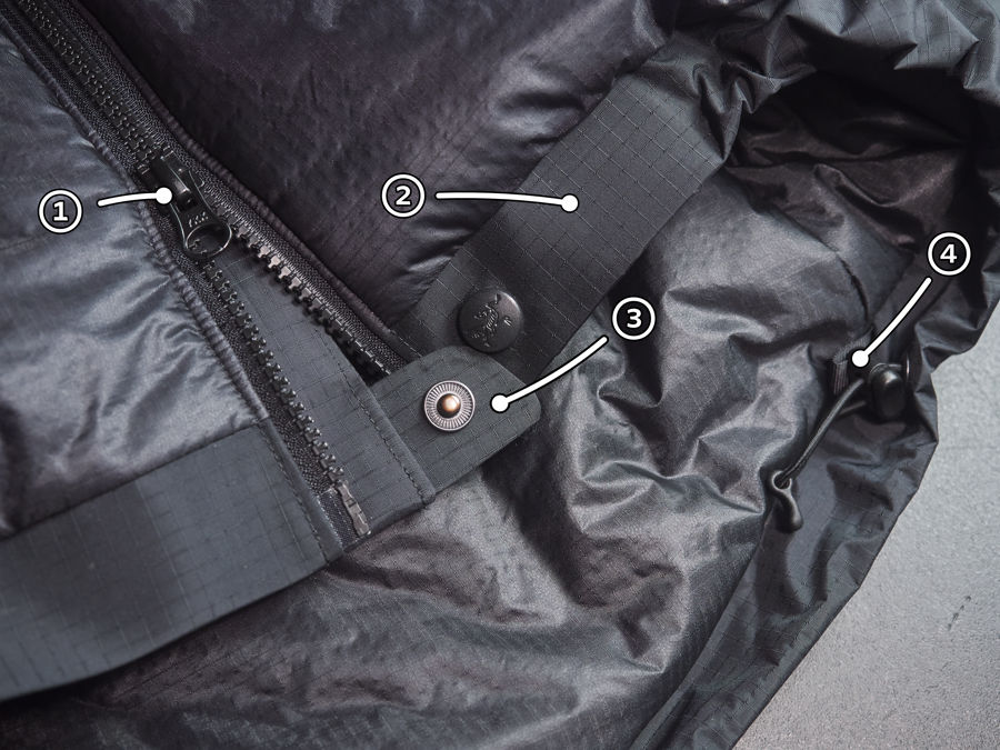 A photo of the Dually main zip draft tube. With the draft tube twisted showing the back of the draft tube and how it is integrated with the liner textile. As well as the front of the draft tube with the stiffening and zip.
